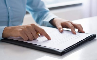 Closeup of person reading and studying document. Entrepreneur sitting at desk. Paperwork concept. Cropped view.